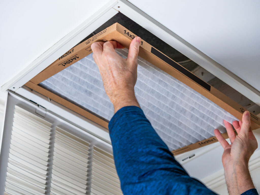 HVAC technician replacing a home air filter in Moreno Valley