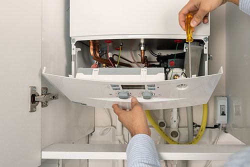 Heating technician repairing a residential boiler in Moreno Valley
