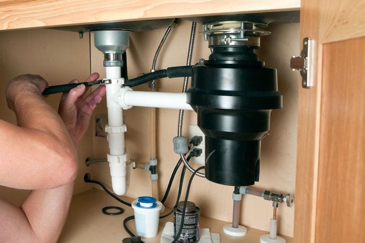 Plumber repairing a garbage disposal in Moreno Valley