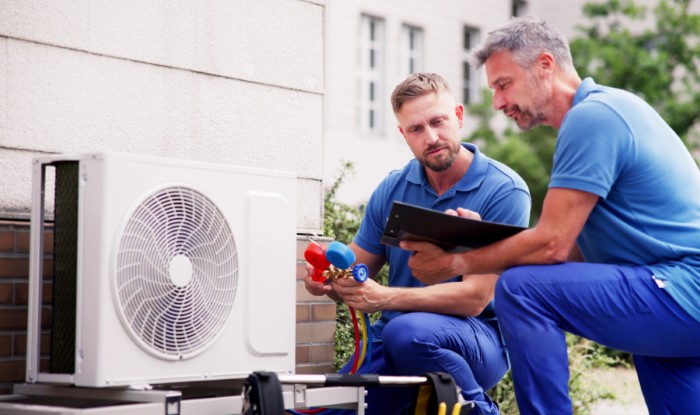 HVAC technicians installing an outdoor air conditioning unit in Moreno Valley