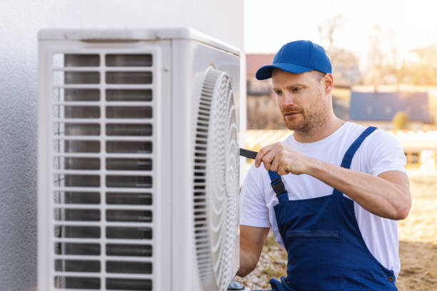 HVAC technician servicing an outdoor air conditioner in Moreno Valley