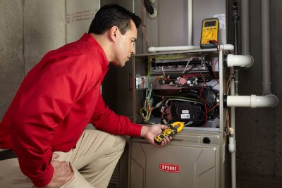 Heating technician diagnosing a furnace repair in Moreno Valley