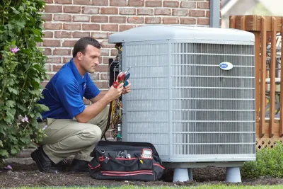 HVAC technician inspecting an outdoor AC unit in Moreno Valley